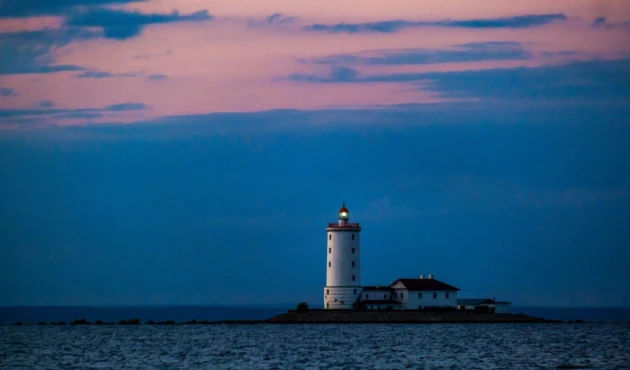 Tolbukhin Lighthouse, built by order of Peter I. We are unlikely to reach it, but we can catch its outline by looking through the mouth of the dam into the open Gulf of Finland.